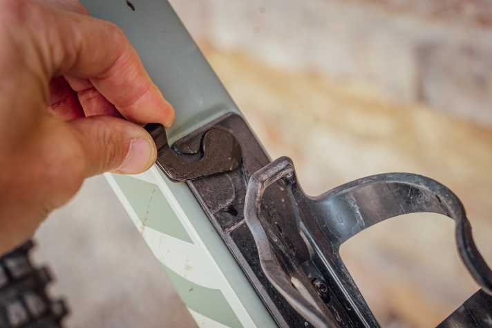 A small lever opens access to the storage space in the down tube. The lid sits precisely and firmly on the opening