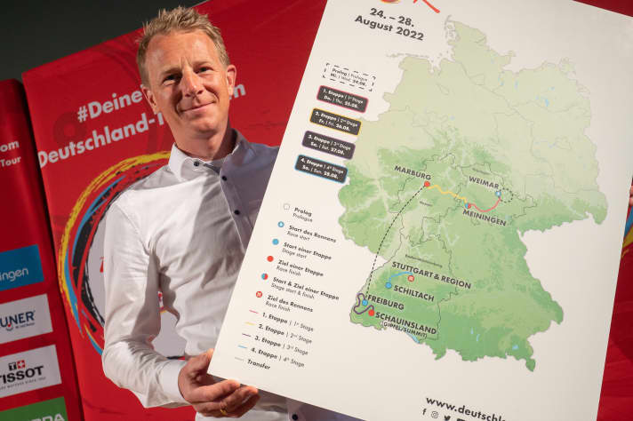 Fabian Wegmann, Sporting Director of the Deutschland Tour, holds a map showing the route of the Tour during the route presentation of the Deutschland Tour 2022. The cycling race will take place from 24 to 28 August 2022 in four stages plus a prologue. It starts in Weimar and leads via Marburg and Freiburg to Stuttgart.