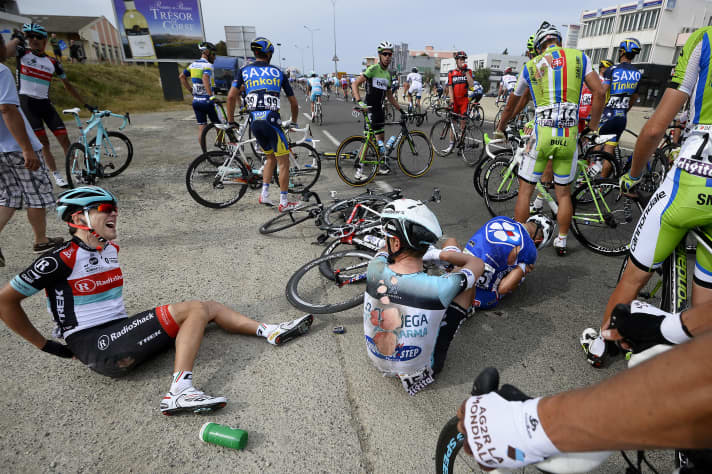 Tony Martin sitzt gezeichnet vom Sturz auf der Straße.