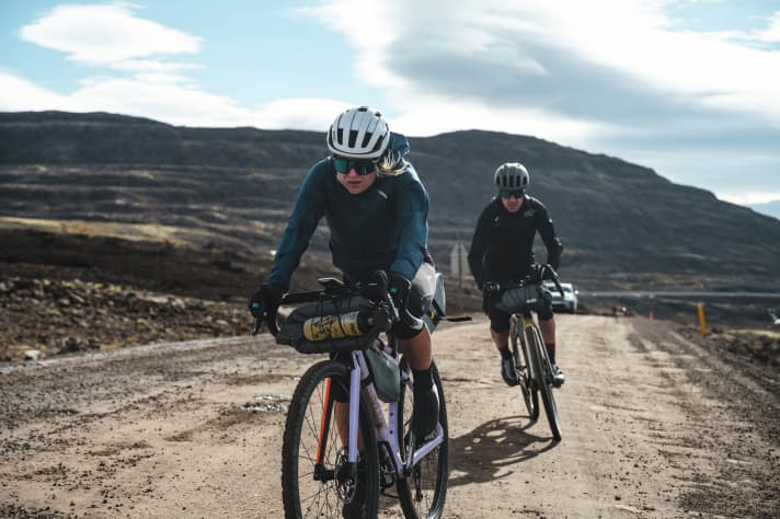 Sturm bläst die Radler fast von der Piste. Irgendwann ist Schieben nicht langsamer als Fahren