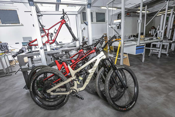 Die vier manipulierten Canyon Spectral vor unserem neuen Steifigkeitsprüfstand. Durch Schwächung bzw. Verstärkung der Rahmen konnten wir unterschiedliche Steifigkeiten an Hauptrahmen und Hinterbau realisieren. Für die Blindtests am Geißkopf wurden die Rahmen komplett abgeklebt.
