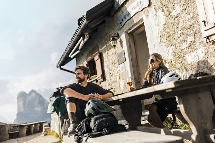 Beim Aperol-Sprizz ganz entspannt auf die große Vorstellung warten: das berühmte Enrosadira - wenn die weißen Dolomiten-Felsen im Abendlicht zu “glühen” beginnen.