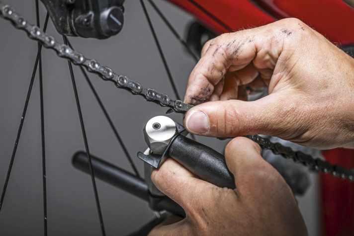 Once the rivet pin is completely screwed in, the protruding end can be broken off using the device on the chain riveter or combination pliers.
