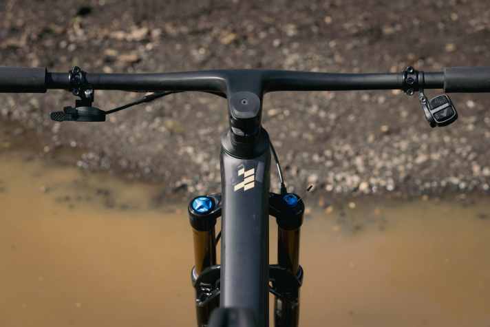 A one-piece carbon handlebar/stem combination saves weight on the top model.