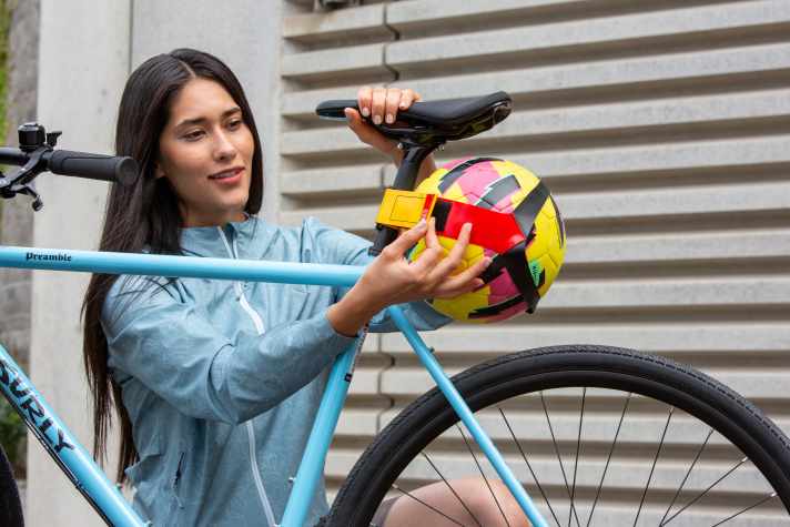 Raaatsch... The football is attached to the seat post of the bike with a Velcro strap.