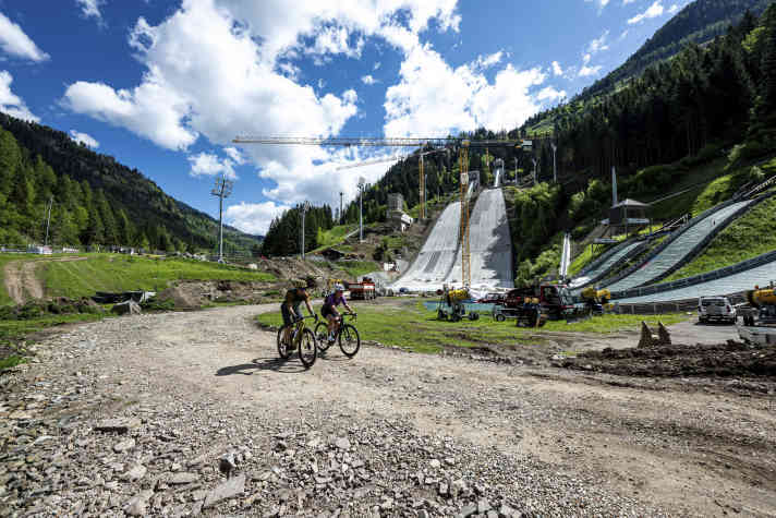 Rund ein halbes Jahr vor den Olympischen Winterspielen 2026 wird an den Sportanlagen im Val di Fiemme noch fleißig renoviert und gebaut.