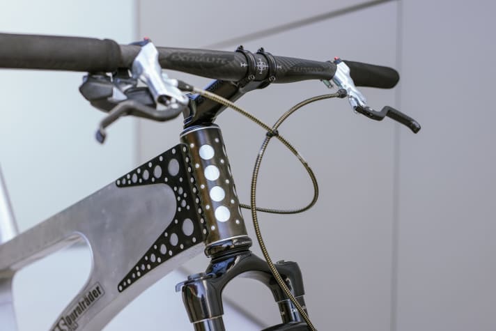 The perforated, dark sleeve connects the steel head tube with the rest of the frame, which is made entirely of aluminium sheet metal. Photo: Adrian Vesenbeckh