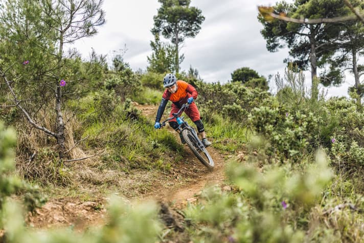 While the bike tilts strongly inwards, the body axis remains as vertical as possible.