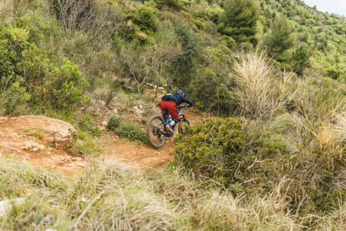 In der Luft, vor der Landung, nimmt der Fahrer über dem E-MTB wieder eine zentrale Position ein. Im Idealfall landet man mit beiden Rädern gleichzeitig und federt den Schlag mit Armen und Beinen ab.