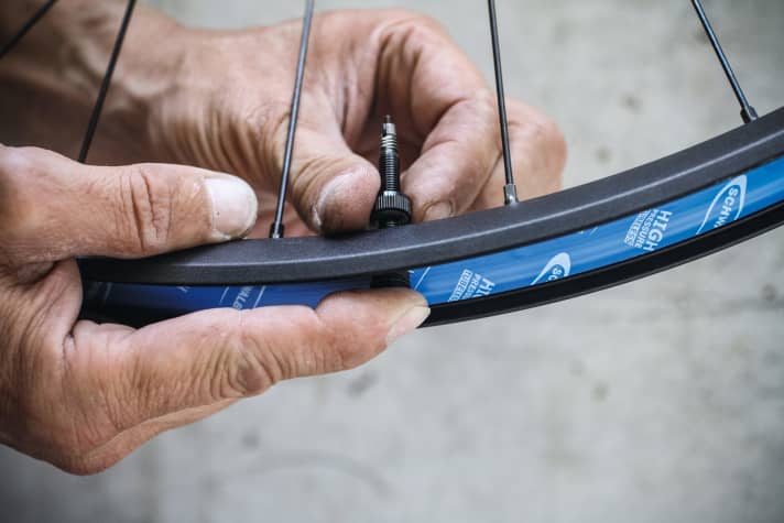   Bild 3: Tubeless-Ventil verbauen: Ventil einsetzen und mit der Rändelmutter fest mit der Felge verschrauben. Für den optimalen Sitz, das Ventil beim Festziehen zusätzlich von innen ins Felgenbett drücken. Achtung: Tubeless-Ventile können runde oder rechteckige Köpfe haben. Bei rechteckigem Kopf darauf achten, dass die lange Seite parallel zur Laufrichtung der Felge ausgerichtet ist, damit der Gummikopf des Ventils möglichst plan im Felgenbett liegt.