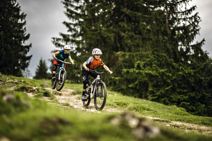 With its long wheelbase and flat steering angle, the Ben e-bike is equipped for fast downhill sections. The <a href="https://www.awin1.com/cread.php?awinmid=14805&awinaffid=471469&clickref=B+Woom+Up+6&ued=https%3A%2F%2Fwoom.com%2Fde_EN%2Ffahrraeder%2Fup-6%3Fvariant%3Ddefault-title" target="_blank" rel="noopener noreferrer">Woom Up6</a> * impresses with its manoeuvrable geometry and finely responsive fork. Left: On pull