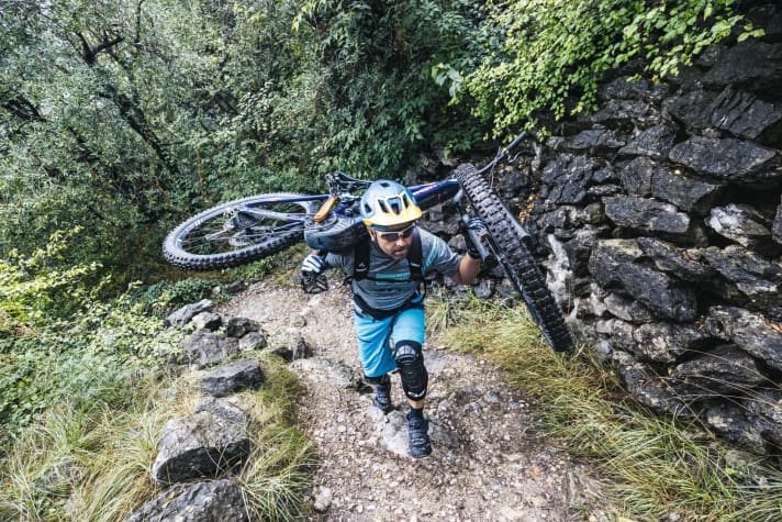   Positionieren Sie jetzt das Bike so, dass möglichst viel Gewicht auf dem Rucksack lastet. Um Kraft zu sparen, machen Sie möglichst kleine Schritte. Im Idealfall ist das Bike auf Ihrem Rucksack so ausbalanciert, dass Sie es kaum halten müssen (3).