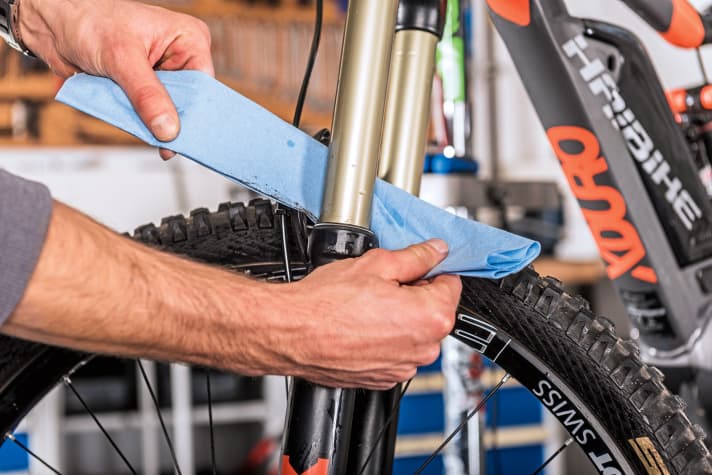    2 Fork: If the dust seals are clean, the fork is fine. Remove dust and dirt with a cloth. Do not use degreasers or aggressive cleaners. Some manufacturers also advise against treating the stanchions (light-coloured) with special penetrating oils. Our tip: Turn the bike upside down - this allows the fork oil to run towards the seals. You can also grease the seals from the outside with a little fork oil, then compress the fork a few times. Remove the remaining oil with a clean cloth so that no dirt sticks to it.    
