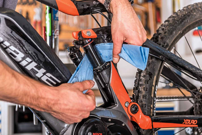    3 Damper: The damper also likes it when the area around the dust seal is clean. Proceed in a similar way to the fork: use a clean cloth to remove dust and dirt. You can apply some damper oil to the damper piston and seal. Then compress the shock a few times by applying pressure to the saddle from above. Otherwise, as with the fork, turn the bike upside down.    