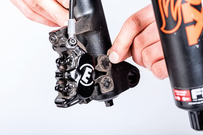    3 Beläge entnehmen: Lassen sich die magnetisch gehaltenen Beläge in diesem Moment nicht leicht entnehmen, sind die Kolben möglicherweise doch noch nicht weit genug auseinandergedrückt. In diesem Fall wiederholen Sie Vorgang 1, und probieren es erneut. Klappt es immer noch nicht, entnehmen Sie die Bremsbeläge einzeln. 