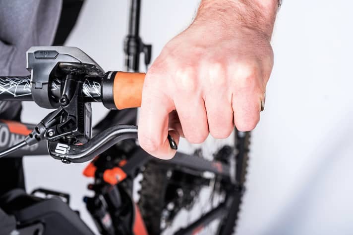    Positioning the brake lever:  On 99% of our test bikes, the brake lever clamps are positioned directly on the handlebar grip at the factory - a deadly sin in terms of ergonomics. For ideal positioning, mount the brake lever clamp so far inwards on the handlebars that the index finger can comfortably pull the brake lever without the hand slipping too far out towards the end of the grip.    