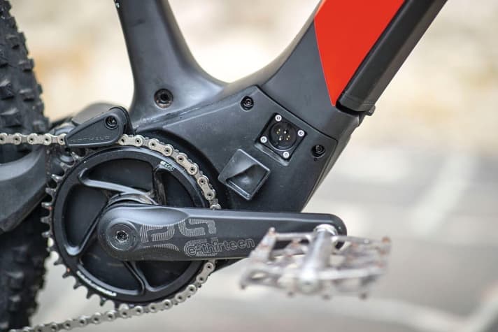   The battery can be charged either externally or in the bike. With the latter method, the charging cable is connected to a socket in the motor housing. The magnetic cover also holds onto the carbon fibre thanks to the metal insert.