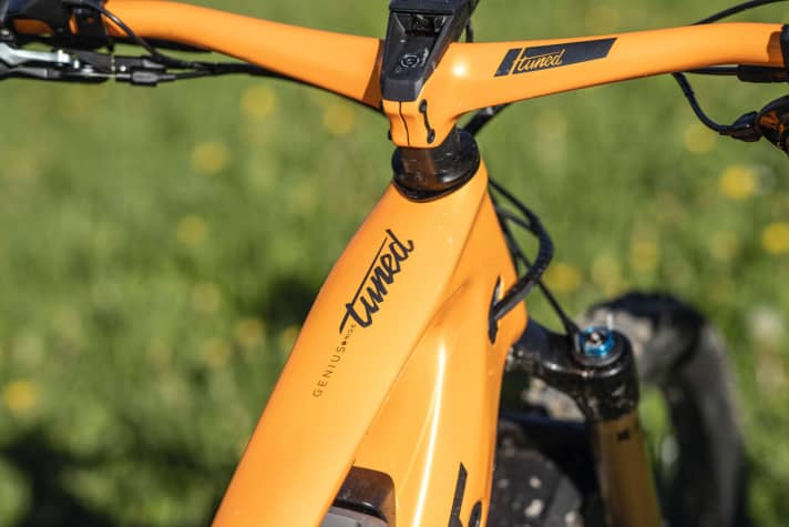   Neben dem grellorangen Lack verrät auch der verschnörkelte "tuned" Schriftzug den Carbonrahmen.