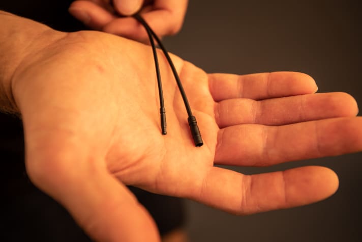   Many small details add up to a significantly smaller and lighter motor. Shimano has developed new cables (left) for the EP8 to replace the thicker Di2 cables (right). As a result, all connectors in the interior can be made more compact. Internal cable routing is also made easier.