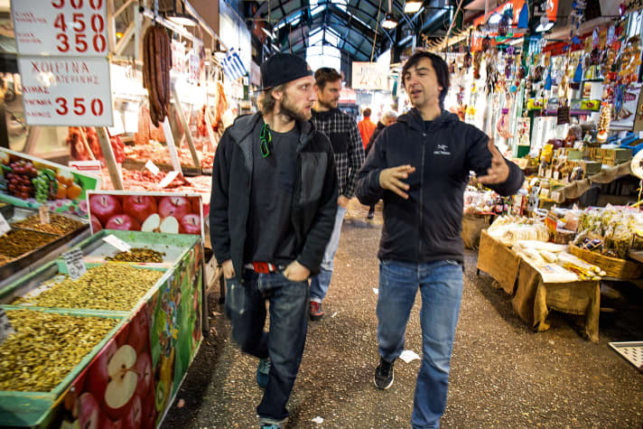   Mittags geht es durch die Markthallen zur Lieblings-Taverne. Tasos (rechts im Bild) ist von der IMBA zertifizierter Bikeguide. Auch das nach­haltige Trailbau-Handwerk hat er nach deren Richtlinien gelernt.