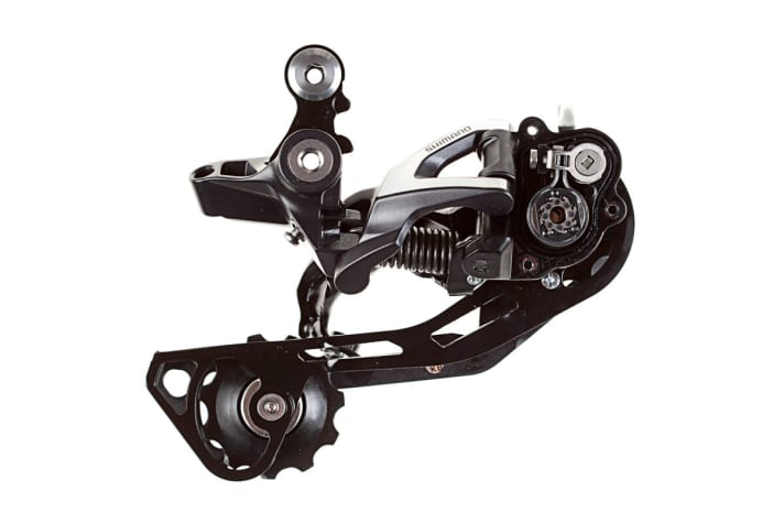   Shimano SLX-Schaltwerk mit Shadow-Plus-Technologie: Unter dem (fürs Foto entfernten) Deckel sitzt der Mechanismus. Die Federvorspannung ist bei Shimano teilweise einstellbar. Shadow Plus ist in Shimano-Schaltwerken ab der Deore-Gruppe erhältlich.