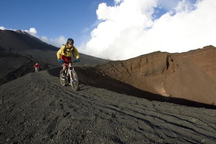   The black lava dust crunches away from the studs of the MTB tyres.