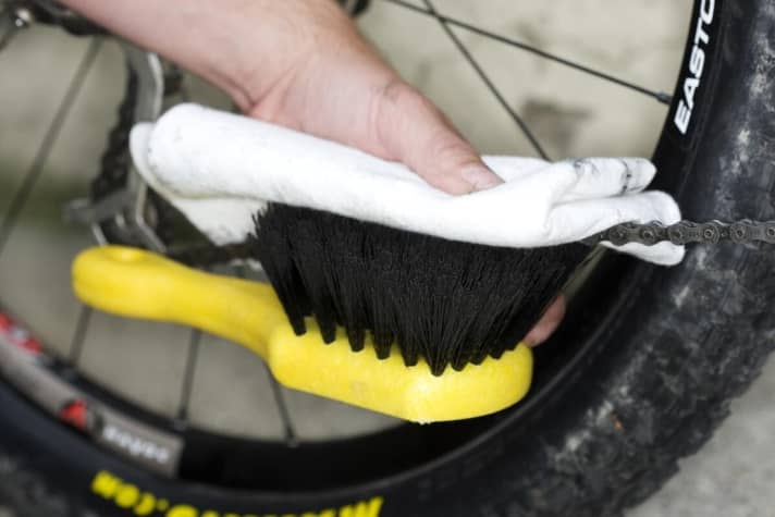   Pull through: As with the sprocket set, carefully spray the chain with degreaser. Then place the chain between the brush and cleaning cloth and turn the crank at idle speed. Add variation to the chain sandwich: first place the cloth on top of the chain, then on the bottom.