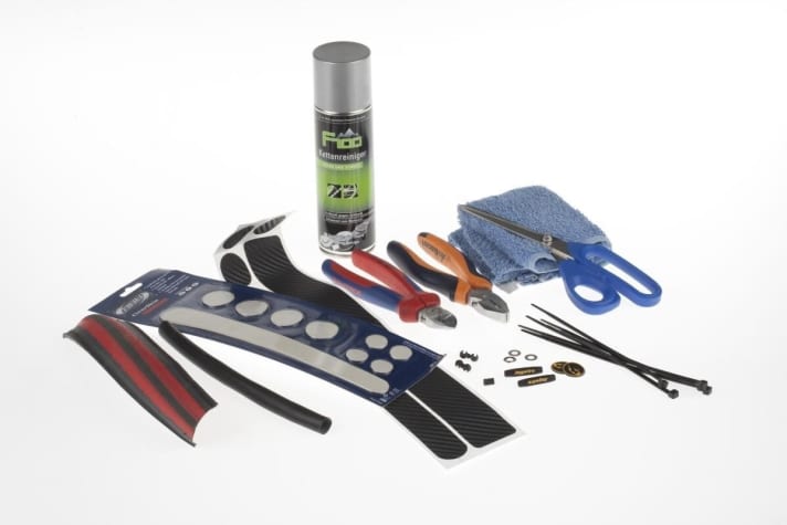   You should protect a new or freshly painted frame from stone chips and abrasive cables. A piece of old road bike tyre plus inner tube or a piece of plastic tube from the DIY store are suitable as impact protection for the chain and seat stays. Either adhesive films (BBB, H & S Bike Discount) or rubber protectors (Jagwire) protect the down tube and under the shift and brake cables. Lightweight washers (size: M5) and cable ties are also required to build cable guides. To clean the adhesive surfaces, use a cloth and chain cleaner, for example. You will then only need side cutters, combination pliers and scissors for cutting and fitting.