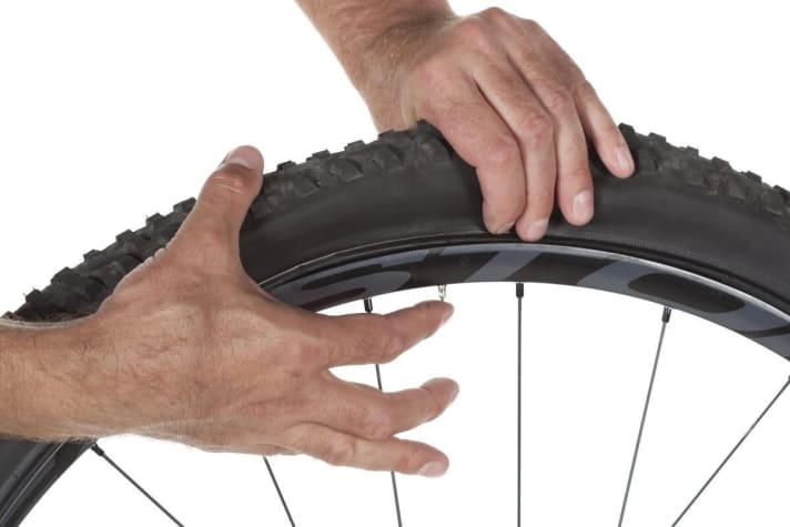 Detaching the tyre from the rim well Before you start to pull the tyre off the rim, first detach it from the rim well. The tyre is often stuck to the inside of the rim all the way round. Therefore, press the tyre firmly together all the way round, starting from the valve, until the entire tyre bead lies loosely in the centre of the rim well.