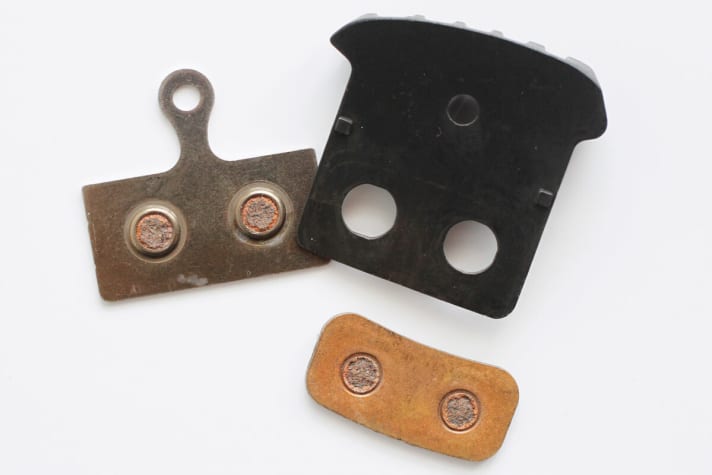   The backing plate of the Shimano F03C pad with cooling fins is divided into two parts. An aluminium plate with cooling fins is reinforced by a steel plate on the back.