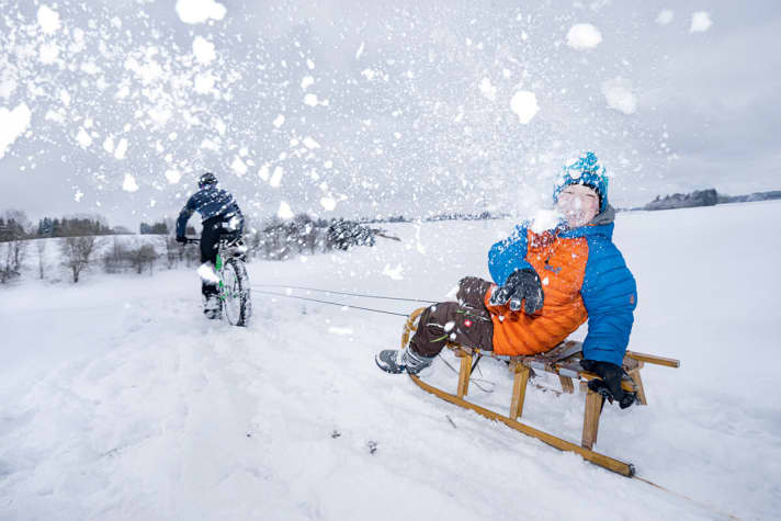 Da freut sich Junior Xavi: Mit den 350 Watt des Papas als Zugmaschine auf dem Trek Farley 8 kriegt Schlittenfahren einen ganz neuen Drive. Die Seile hat Franz in den Gepäckträgerösen fixiert.