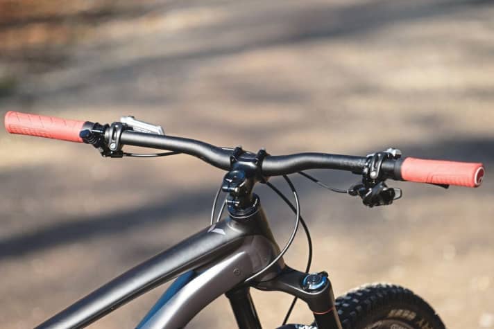   Enduro style: short stem, wide handlebars, a gear lever on the right and the control for the dropper post on the left.