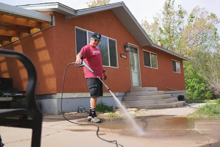   Housework is a must: Herbold sprays the concrete driveway clean. The house in Moab is used as a test centre.