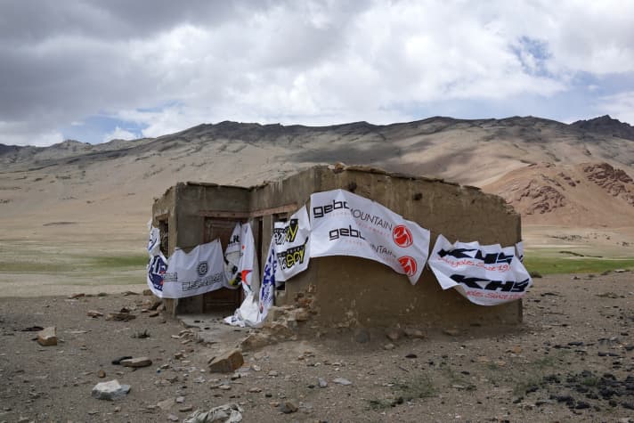   Werbung muss sein. Die Möglichkeiten zum Hissen der Banner sind im kargen Himalaya aber äußerst rar. Links erkennt man den Schriftzug von Bressan, einer der diversen Kleinsponsoren des Sky is the Limit, das vom italienischen Reisespezialisten Wheels Without Borders organisiert wird.