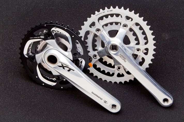  Rechts eine alte Shimano Deore-Kurbel, links eine aktuellere XT-Kurbel.