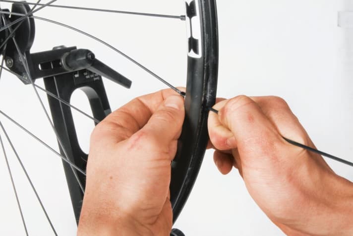   Vor allem bei tiefen Nippellöchern hilft es, den Speichennippel mit Hilfe einer losen Hilfsspeiche einzufädeln.