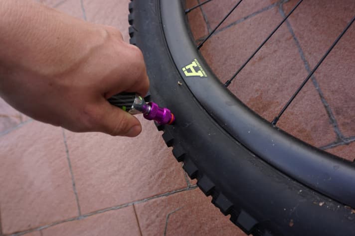   Den Stachel komplett in den Reifen stoßen, bis beide Löcher des Metallschafts im Inneren des Reifens liegen. Dann die Kartusche komplett auf den Kopf der Pumpe drehen. Ist die Kartusche geöffnet, wird der Reifen mit Luft befüllt. Achtung, beim Öffnen der Kartusche wird diese schlagartig eiskalt. Am besten immer mit Handschuhen arbeiten.