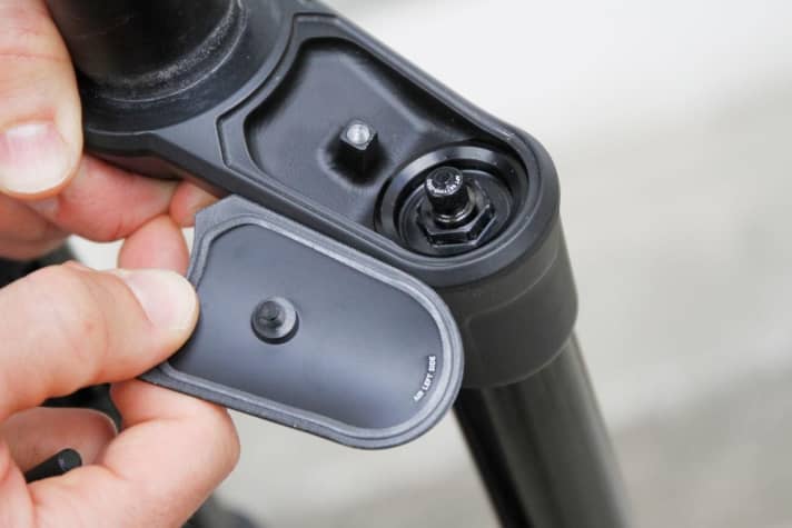   Both sides of the fork crown have a cover that can be unscrewed. The valve for the air spring is on the left and the damping adjustment is on the right.