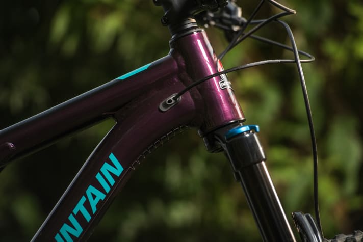   The cables disappear behind the head tube inside the frame.