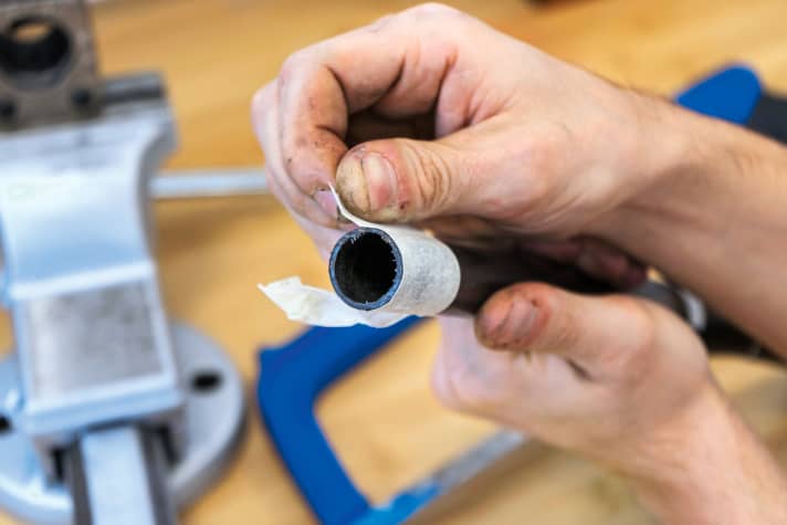 1. Schnittfläche abkleben: Bevor ich loslege, klebe ich die Schnittstelle mit Kreppband ab (anderes Klebeband geht auch). Das verringert das Ausfransen und sorgt für eine schöne Schnittkante. Da feine Carbon-Splitter nicht ungefährlich sind und in die Haut eindringen können, sind für die nächsten Schritte Handschuhe empfehlenswert. Carbon-Splitter lassen sich nur schwer rückstandslos aus der Haut entfernen.