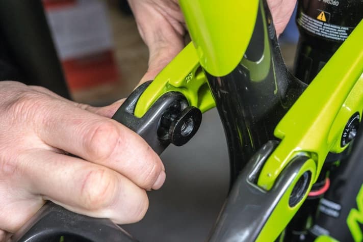   Wenn die entsprechende Verschraubung gelockert, aber noch nicht komplett getrennt ist, kann der Bolzen, auf dem die Lager laufen, aus dem Gelenk gedrückt werden. Dann die Verschraubung komplett lösen und den Bolzen mit der Schraube aus dem Gelenk nehmen. Vor dem nächsten Arbeitsschritt auch die Verschraubung des gegenüberliegenden Gelenks lösen. 