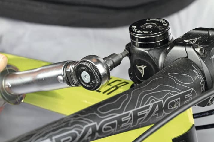   3 Verschraubung des Vorbaus auf dem Gabelschaft kontrollieren. Vorher prüfen, ob das Steuerlager Spiel hat: Vorderbremse ziehen, Bike vor- und zurückruckeln. Bei Spiel Verschraubung des Vorbaus (wie im Bild) öffnen, Deckelschraube nach­ziehen, dann Vorbau wieder anziehen.