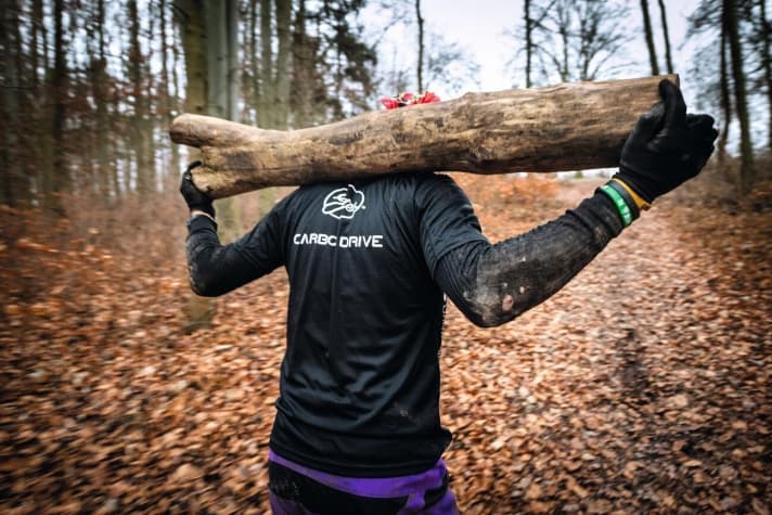   Baumstamm tragen auf dem Rücken