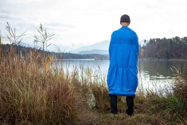 The poncho function of the Vaude Altmann 300 Syn sleeping bag eliminates the need for a thick jacket - saving on luggage and weight.