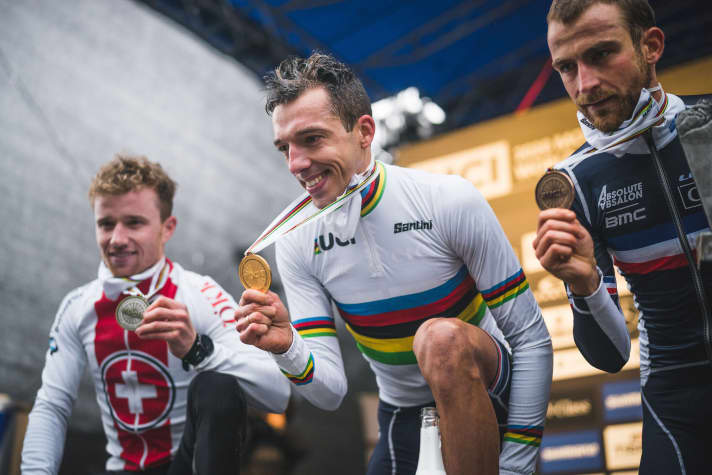   A new face in the rainbow jersey: Jordan Sarrou with Mathias Flückiger (left) and Titouan Carod at the award ceremony.