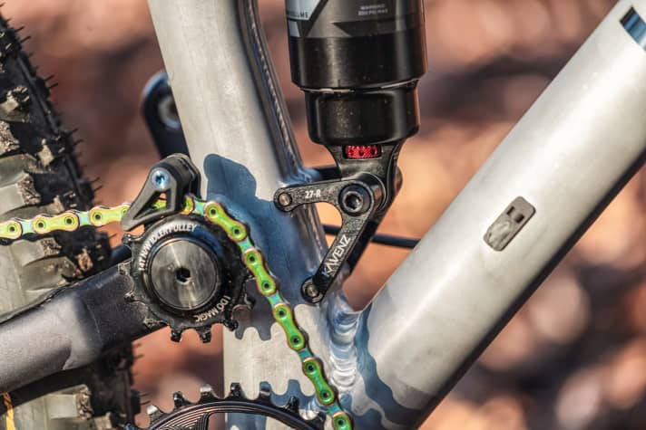   Erst mit Hilfe der Umlenkrolle (Idler-Pulley) ist der hohe Drehpunkt des Hinterbaus realisierbar. Ohne die Umlenkung der Kette wären die Antriebseinflüsse zu extrem.  Anti-Squat und Pedalrückschlag wären zu hoch.