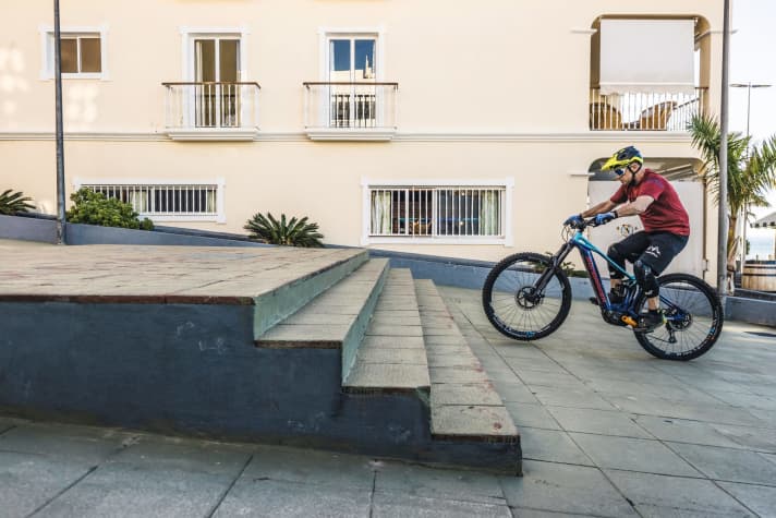   1. Besonders wichtig bei der Anfahrt: das Pedal-Management und ein nicht zu schwerer Gang. Dieser ist ideal gewählt, wenn man mit einer halben Pedalumdrehung etwa eine Radlänge zurücklegt. Vor der Treppe lupft man das Vorderrad, indem man mit dem falschen Fuß beherzt ins Pedal tritt. Gleichzeitig zieht man mit den Armen am Lenker und verlagert den Körperschwerpunkt nach hinten. Jetzt steigt das Vorderrad und bekommt erst ein paar Stufen weiter oben wieder Bodenkontakt.