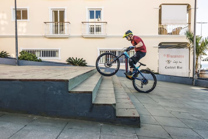   2. Bei kurzen Treppen wie dieser sind weitere Pedalumdrehungen nicht notwendig. Wenn die Treppe länger ist und der Schwung nicht ausreicht, tritt man möglichst konstant weiter. Das Gewicht bleibt dabei hinten, damit das Vorderrad nicht an den Stufen hängen bleibt.