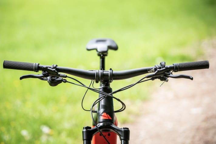   Schickes Detail am Canyon: Das Cockpit wirkt gut aufgeräumt, die Züge verschwinden wie bei den teureren Modellen teilweise im Steuersatz. Auch der hauseigene Sattel mit guter Abstützung nach hinten passt gut ans E-MTB.