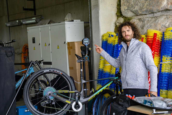   "Yanick the Mechanic" is Schurter's personal mechanic. With his meticulous work, he ensures that Schurter's defect record is better than that of most athletes. Here he presents Nino's new competition bike at the scales. Schurter's new workhorse weighs a ready-to-ride 10.59 kilos. Weight is still important in cross-country racing, but according to Schurter and his mechanic, it is no longer the decisive factor in the choice of material. The more technical the routes become, the more important it is for the bike to function excellently. And it is precisely this excellence that is hoped for from the additional suspension travel, the wide tyres and the telescopic seat post.